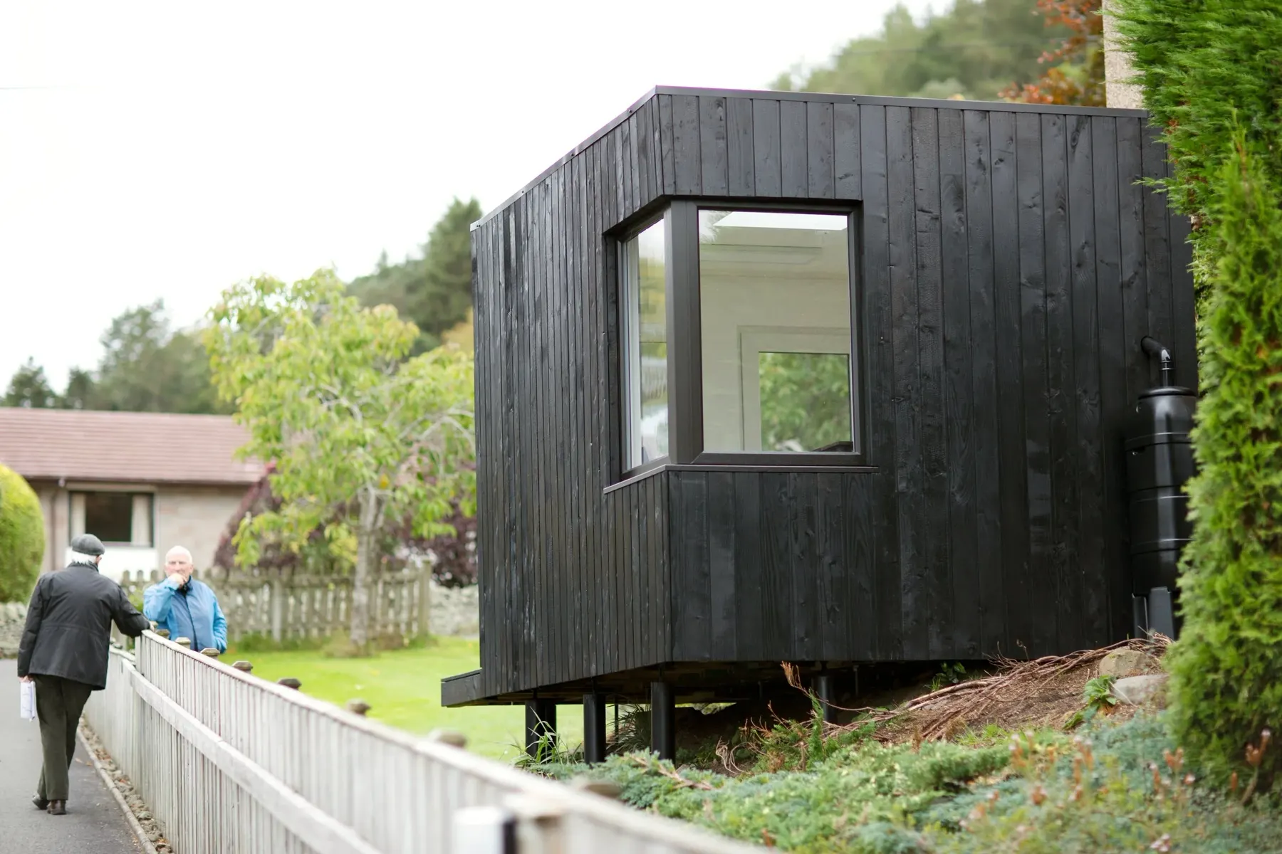 The charred studio against the surrounding garden