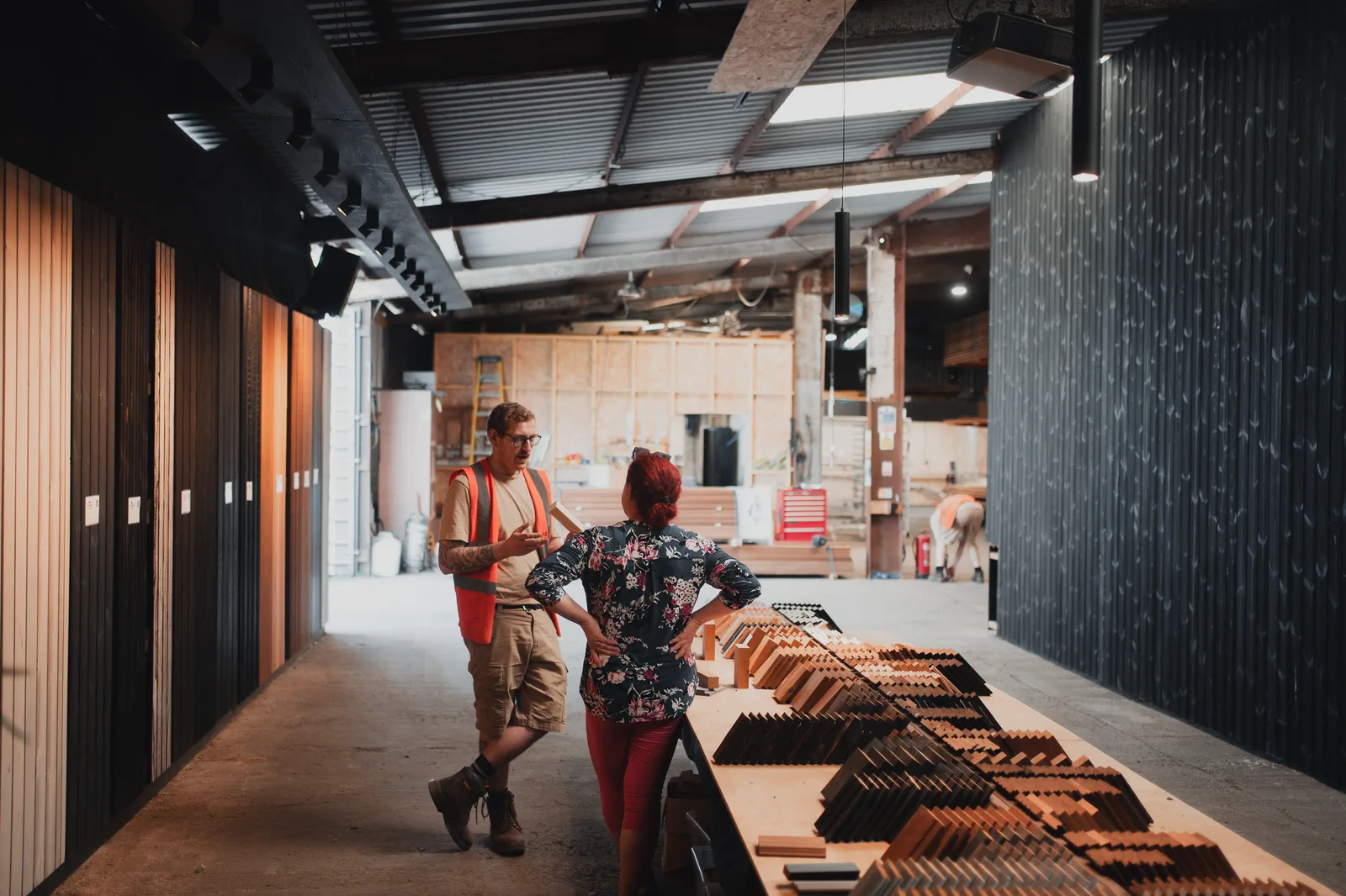 A member of the Tiny Temple team talking a customer along the sample run inside the mill, boards laid out down the bench